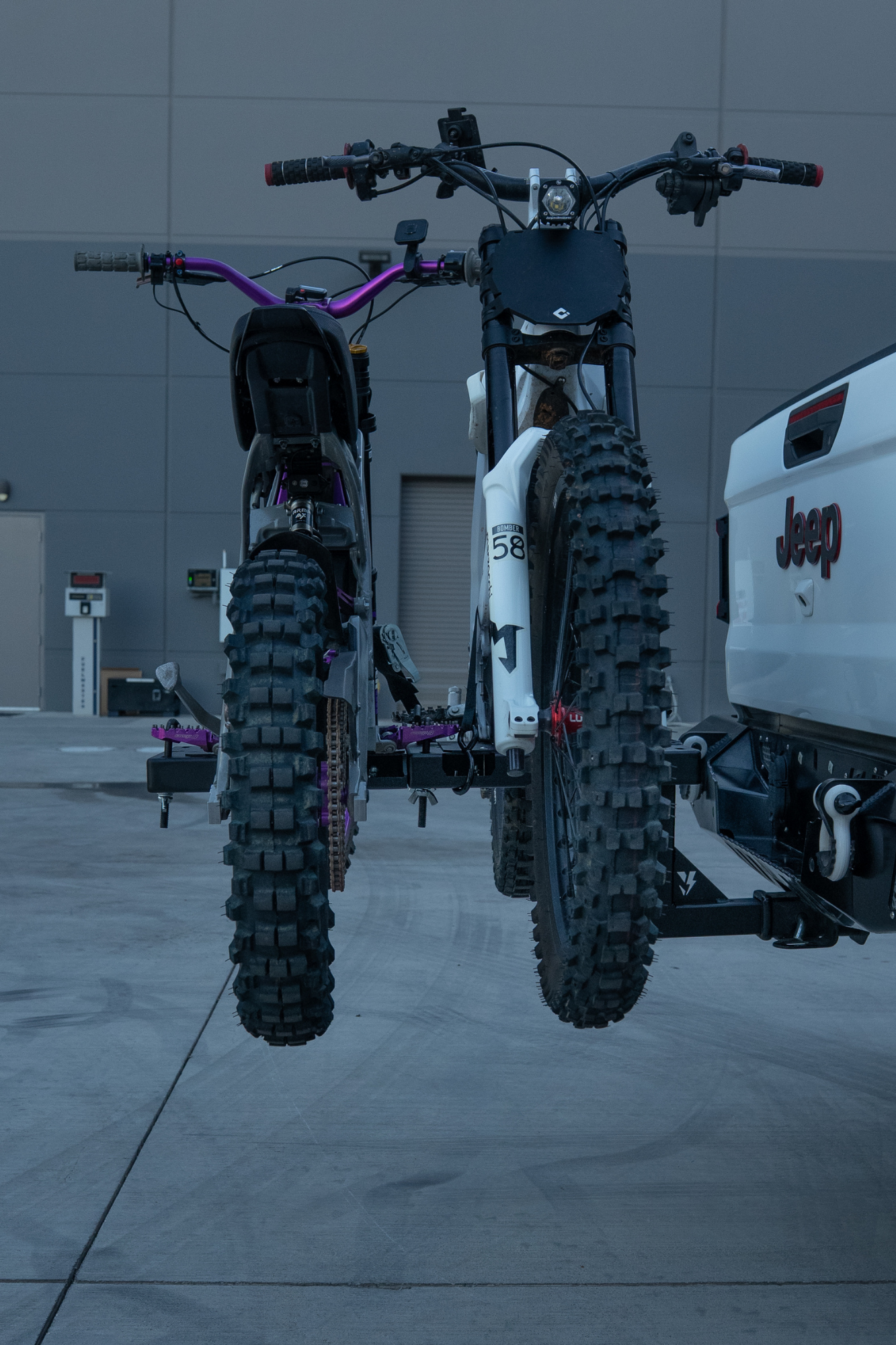 Dual e-moto hitch rack hauling two Surron Ultra Bee electric motorcycles on a 2-inch hitch