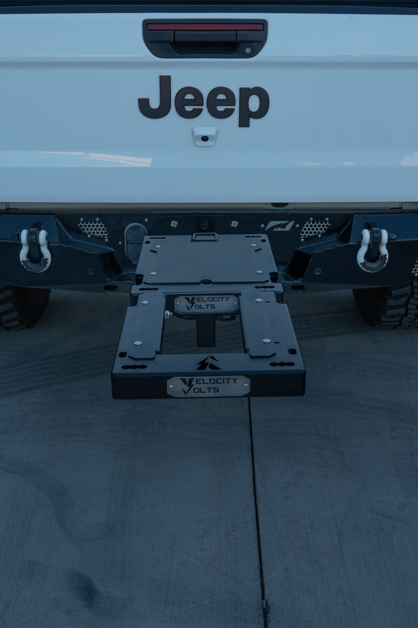 Two-bike e-moto hitch rack on a Jeep loaded with Surron Ultra Bee and Arctic Leopard