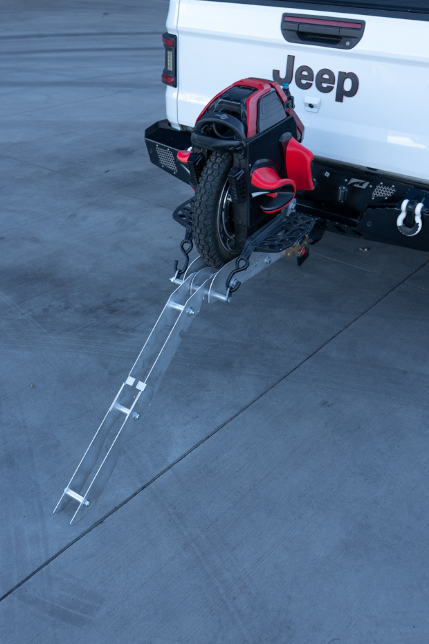 Electric unicycle hitch rack with the loading ramp extended to the ground for roll-on loading