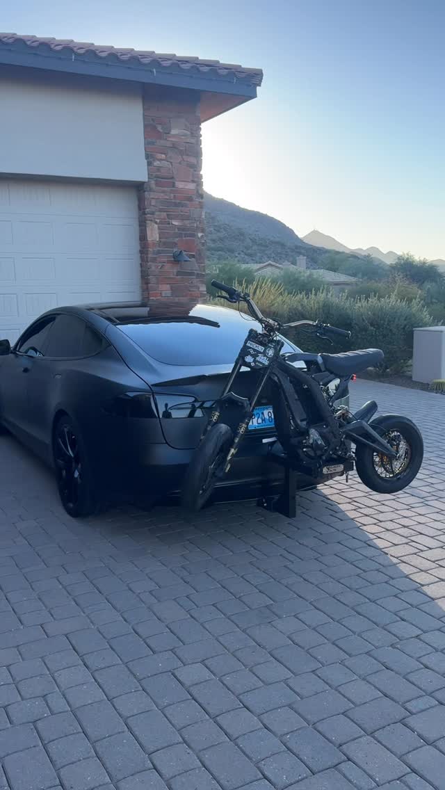 black tesla model s transporting surron light bee using velocity volts charge carrier