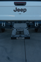 Two-bike e-moto hitch rack on a Jeep loaded with Surron Ultra Bee and Arctic Leopard